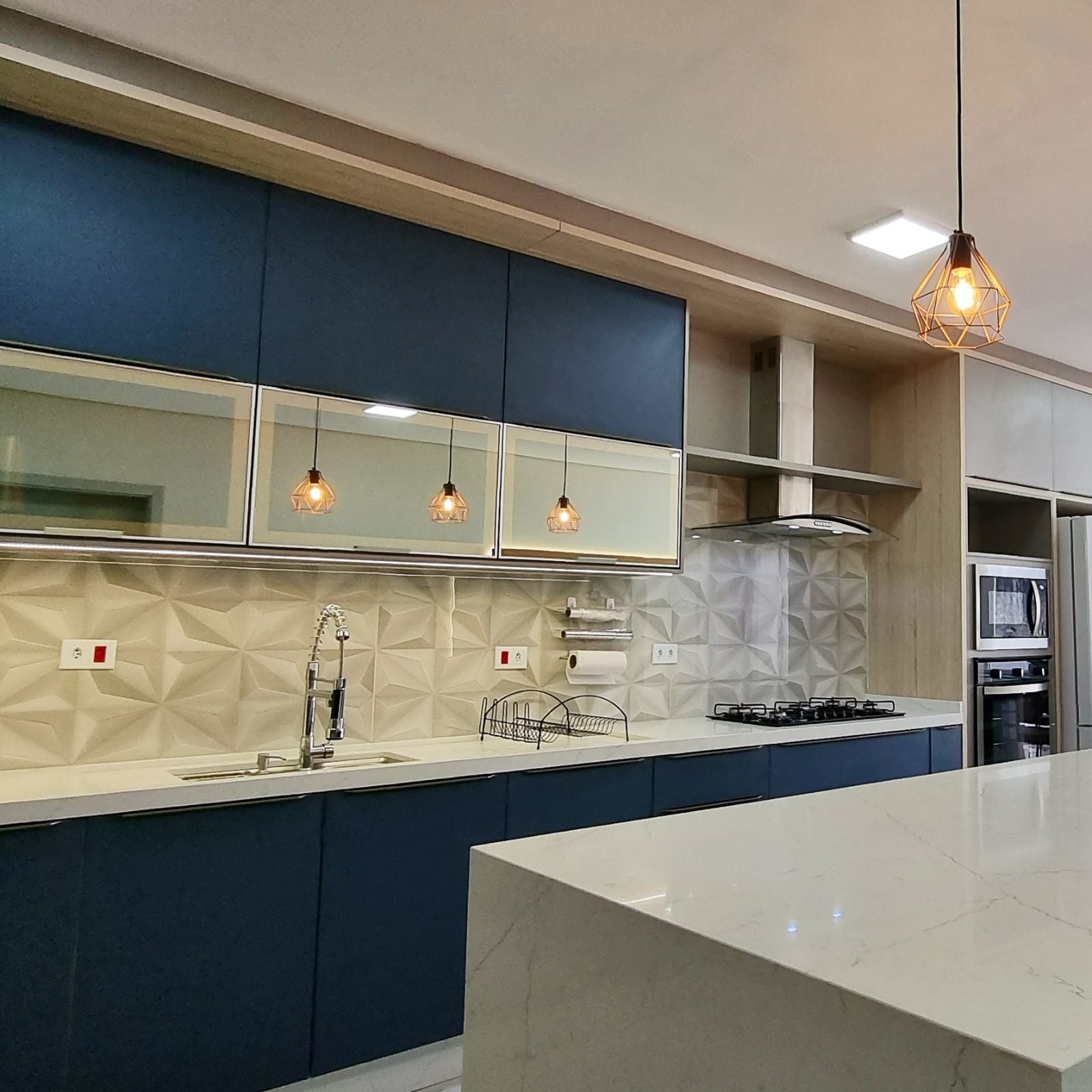 Cozinha planejada azul fosco com bancada em marmore